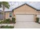 Tan house with white garage door, landscaping, and palm trees at 5914 Fiore Dr, Bradenton, FL 34208