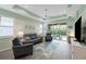 Spacious living room with gray couches, a large TV, and sliding doors to a patio at 5914 Fiore Dr, Bradenton, FL 34208