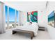 Bright bedroom featuring modern art, stylish bench, and an ocean view from the large windows at 6100 Midnight Pass Rd # 401, Sarasota, FL 34242