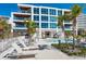 Modern condominium with multiple floors, balconies, pool and lounge area and mature palm trees at 6100 Midnight Pass Rd # 401, Sarasota, FL 34242