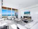 Bright living room with modern decor, fireplace, furniture and ocean views through expansive windows at 6100 Midnight Pass Rd # 401, Sarasota, FL 34242