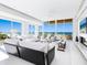 Bright living room with modern decor, furniture, fireplace, and ocean views through expansive windows at 6100 Midnight Pass Rd # 401, Sarasota, FL 34242