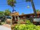 Restaurant with wooden exterior, featuring outdoor dining, tropical plants and signage at 6100 Midnight Pass Rd # 401, Sarasota, FL 34242