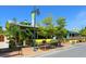 Street view of a yellow building with outdoor seating and tropical landscaping at 6100 Midnight Pass Rd # 401, Sarasota, FL 34242