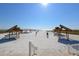 Beach access with wooden gazebos and lounge chairs at 6140 Midnight Pass Rd # 902, Sarasota, FL 34242