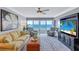 Living room with ocean view, featuring comfortable seating and large TV at 6140 Midnight Pass Rd # 902, Sarasota, FL 34242