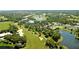 Aerial view of lush golf course community with lakes and tennis courts at 6947 Lennox Pl, University Park, FL 34201