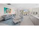 Open living area with light gray sofa and chairs, large windows overlooking the pool area, and a modern area rug at 6947 Lennox Pl, University Park, FL 34201