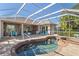 Relaxing kidney-shaped pool and spa with screened enclosure at 6947 Lennox Pl, University Park, FL 34201