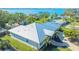 Aerial view showcasing a home's metal roof, landscaping, and waterfront proximity at 7820 Holiday Dr, Sarasota, FL 34231