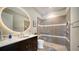 Modern bathroom with round mirror and walk-in shower at 7820 Holiday Dr, Sarasota, FL 34231