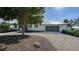 White, single-story home with a gray garage and mature landscaping at 7820 Holiday Dr, Sarasota, FL 34231