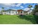 Back exterior view of the house with a large deck and lush green lawn at 7820 Holiday Dr, Sarasota, FL 34231