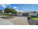 Front view of the house with a gravel driveway and landscaping at 7820 Holiday Dr, Sarasota, FL 34231