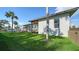 Side view of the house with a large grassy yard and palm trees at 7820 Holiday Dr, Sarasota, FL 34231