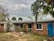 Brick ranch home with a metal roof and blue door at 7820 Midnight Pass Rd, Sarasota, FL 34242