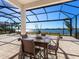 Covered patio with table and chairs overlooking lake at 7917 Mainsail Ln, Sarasota, FL 34240