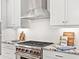 Stainless steel range and hood in a modern kitchen with granite countertops at 7917 Mainsail Ln, Sarasota, FL 34240