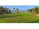 Expansive grassy lawn with lake views and palm trees at 7917 Mainsail Ln, Sarasota, FL 34240