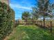 Small, fenced backyard with grassy area and mature shrubs at 8253 Grande Shores Dr, Sarasota, FL 34240