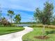 Curved community path alongside a lake with lush landscaping at 8253 Grande Shores Dr, Sarasota, FL 34240