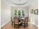 Bright dining room featuring hardwood floors, a round table, and a tray ceiling at 8253 Grande Shores Dr, Sarasota, FL 34240