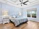 Serene main bedroom features light blue walls, hardwood floors, and a ceiling fan at 8253 Grande Shores Dr, Sarasota, FL 34240