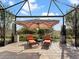 Covered patio with lounge chairs and umbrella at 8253 Grande Shores Dr, Sarasota, FL 34240