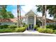 Exterior of the clubhouse with blue double doors, columns, and manicured landscaping at 850 S Tamiami Trl # 408, Sarasota, FL 34236