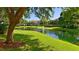 Scenic view of a pond with a fountain, surrounded by green grass and trees at 850 S Tamiami Trl # 408, Sarasota, FL 34236