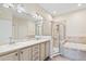 Elegant bathroom with double sinks, a large soaking tub, and a walk-in shower at 9109 Winter Harbour Way, Bradenton, FL 34212