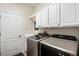 Laundry room with white cabinets and modern washer and dryer at 9109 Winter Harbour Way, Bradenton, FL 34212