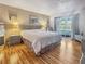 Main bedroom with king-size bed, hardwood floors, and access to patio at 10190 Imperial Point W Dr # 16, Largo, FL 33774