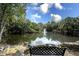 Serene pond with fountain, lush landscaping, and a bench at 1507 Water Oak Way S, Bradenton, FL 34209