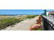 Scenic walkway to the beach with flower pots at 1945 Gulf Of Mexico Dr # M2-313, Longboat Key, FL 34228