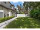 Expansive backyard with a grassy lawn, mature trees, and a privacy fence at 2174 Mcclellan Pkwy, Sarasota, FL 34239