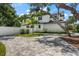 Home's back exterior with paver driveway and white fence at 2174 Mcclellan Pkwy, Sarasota, FL 34239