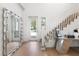 Bright entryway with hardwood floors, large mirror, and staircase at 2174 Mcclellan Pkwy, Sarasota, FL 34239