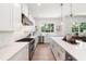 White kitchen features stainless steel appliances and light hardwood floors at 2174 Mcclellan Pkwy, Sarasota, FL 34239