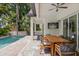 Outdoor patio with dining area, pool view, and large TV at 2174 Mcclellan Pkwy, Sarasota, FL 34239