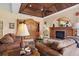 Living room boasts a cozy fireplace and wood-beamed ceiling at 2611 Little Country Rd, Parrish, FL 34219