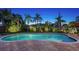 Peaceful kidney-shaped pool with lush landscaping and palm trees at 2651 Leafy Ln, Sarasota, FL 34239