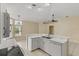 L-shaped kitchen with island, white cabinetry, and tile floors at 3915 Fonsica Ave, North Port, FL 34286