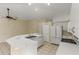 Open kitchen with white cabinets, breakfast bar, and tile floors at 3915 Fonsica Ave, North Port, FL 34286