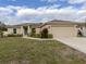 Tan house with brown roof, landscaping, and a two-car garage at 4352 Adelaide Ave, North Port, FL 34288