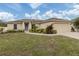 Tan house with brown roof, landscaping, and a two-car garage at 4352 Adelaide Ave, North Port, FL 34288