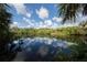 Calm lake reflecting clouds and lush foliage at 4352 Adelaide Ave, North Port, FL 34288
