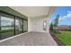 Covered patio with paver stones, sliding glass doors, and views of the lake at 4517 Mondrian Ct, Sarasota, FL 34240