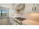 Kitchen features gas cooktop, herringbone backsplash, and water views at 4517 Mondrian Ct, Sarasota, FL 34240
