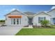 One-story home with gray siding, orange awning, and landscaped yard at 4519 Boxelder Avenue, Parrish, FL 34219